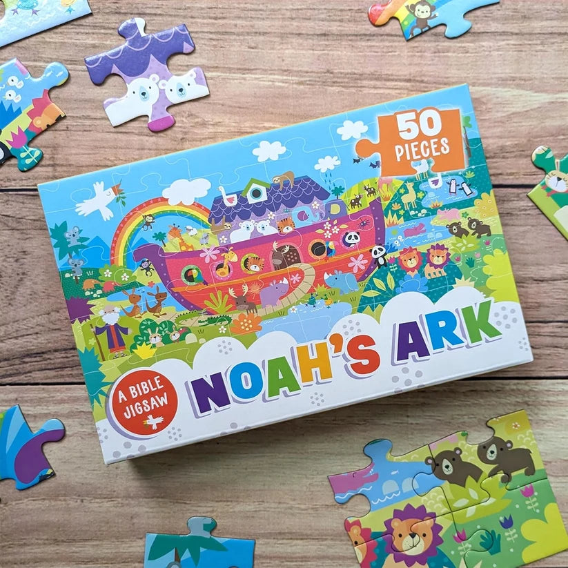 1: Completed Noah's Ark 50-piece kids jigsaw puzzle showing ark, rainbow and animals
2: Close-up of large chunky jigsaw pieces with kangaroo from Noah's Ark puzzle
3: Noah's Ark children's jigsaw box with puzzle pieces spread on table
4: Noah's Ark 50-piece Bible jigsaw puzzle box for kids ages 3 and up